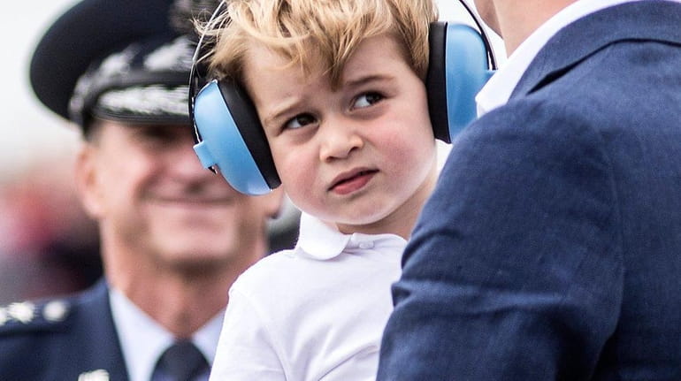 Prince George, wears ear defenders against the roar of aircraft...