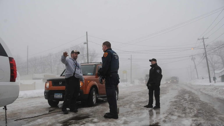 Suffolk County emergency service police officers talk to a stranded...