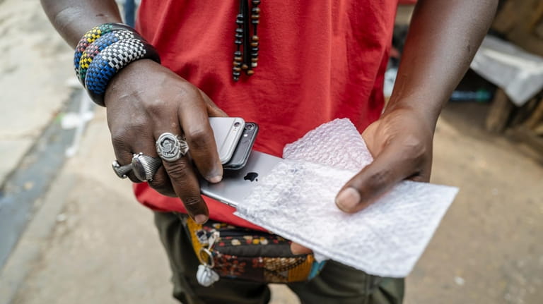 Gueva Ba sells used cell phones in Dakar's Colobane market...