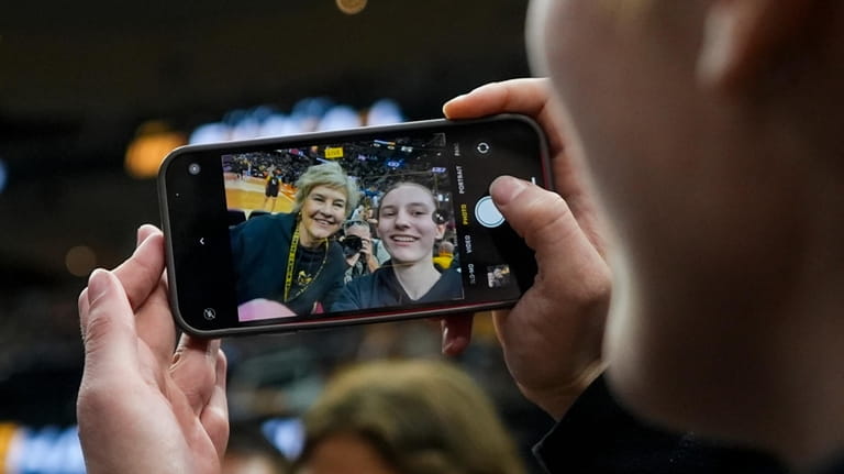 Iowa head coach Lisa Bluder poses for a selfie with...