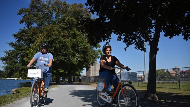 Christina and Robert Santos of Babylon ride bike-share bicycles near...