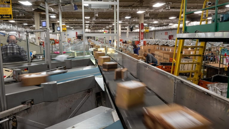 Packages are sorted into bins for delivery at the U.S. Postal...