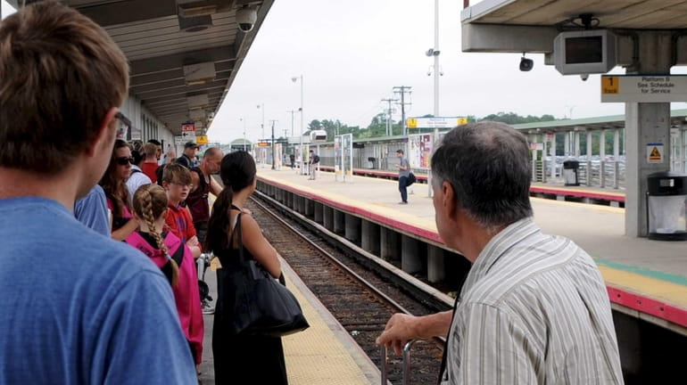 LIRR commuters wait for a westbound train at the Ronkonkoma...