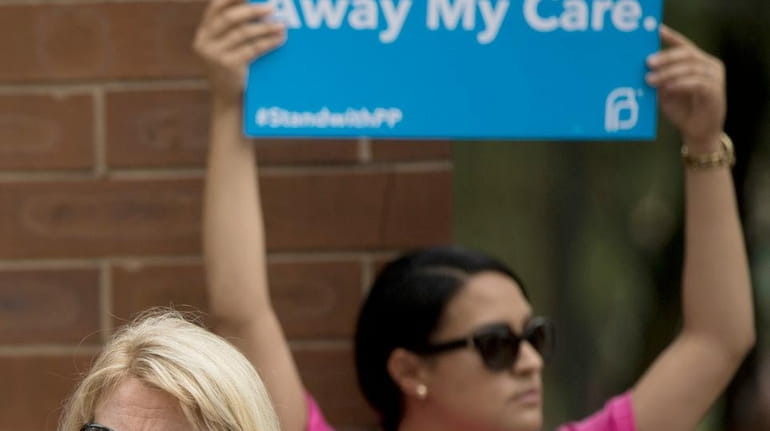 An opponent and supporter of Planned Parenthood demonstrate Tuesday, July...