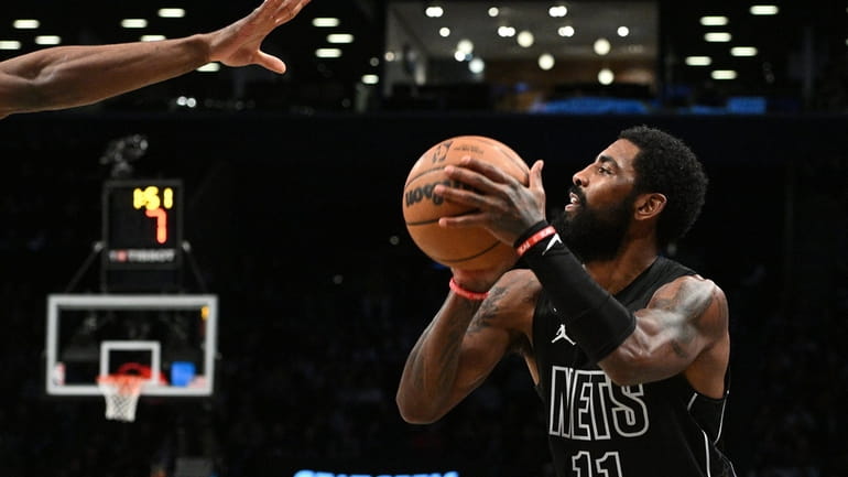Brooklyn Nets guard Kyrie Irving lines up his shot for...