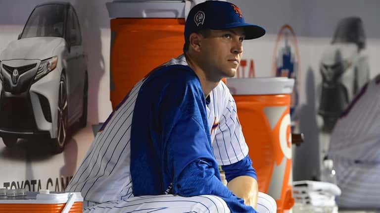 Mets starting pitcher Jacob deGrom looks on from the dugout ...