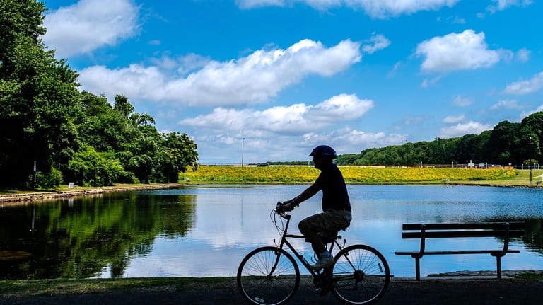 An e-bike rider pedals along the shore of McDonald Pond in...