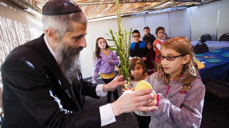 Rabbi Asher Vaisfiche gives a blessing to Jaclyn Printz, 10,...