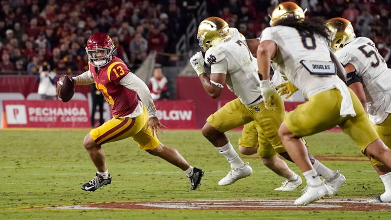 Southern California quarterback Caleb Williams, left, is chase by members...
