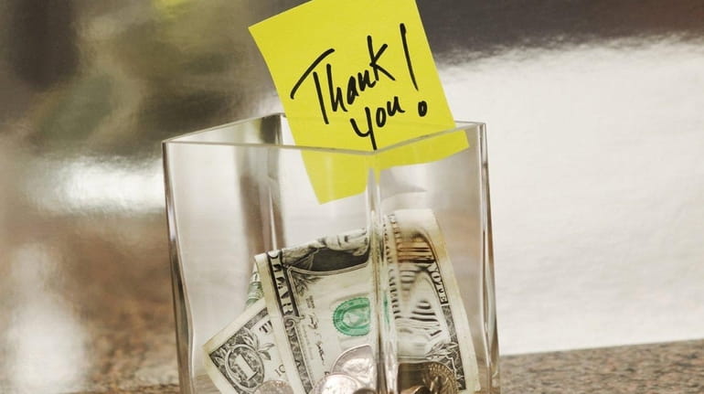 Glass tip jar with a thank you note.