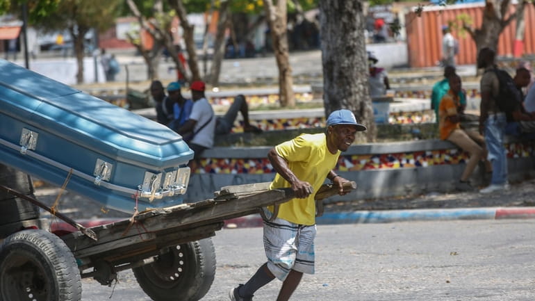 A man transports a coffin using a cart in Port-au-Prince,...