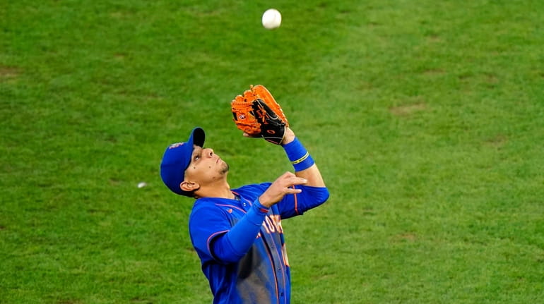 Mets third baseman Andres Gimenez catches a fly out by...