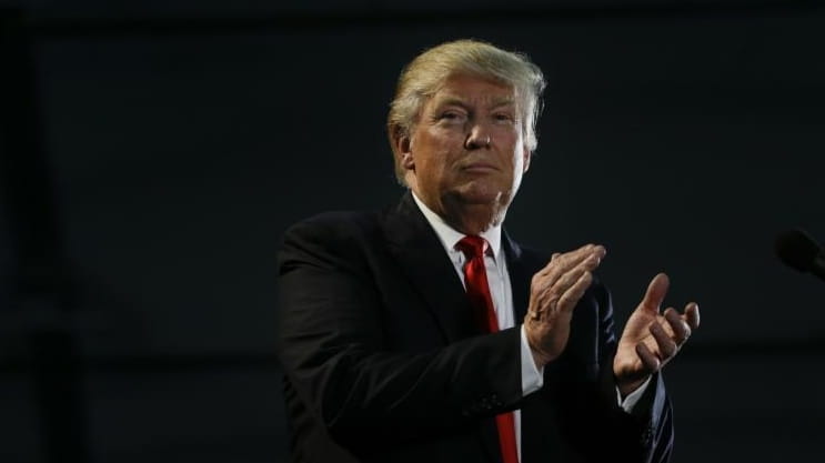 Republican presidential candidate Donald Trump applauds during a rally, Thursday,...