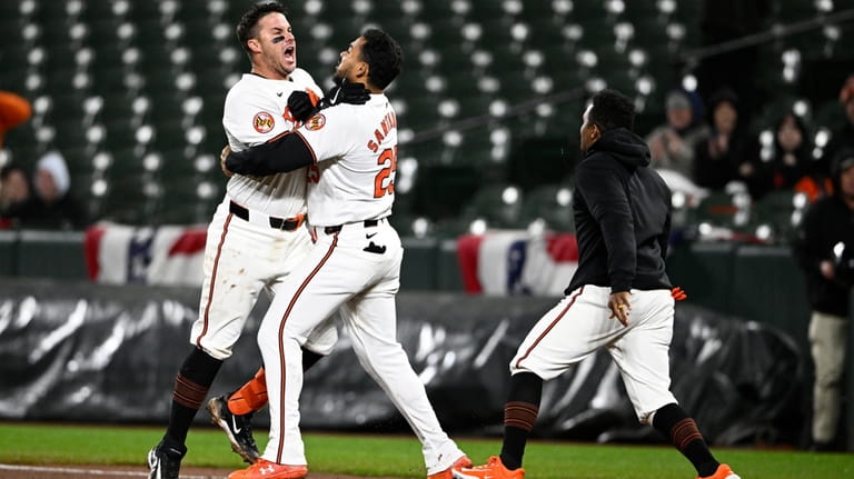 Baltimore Orioles' James McCann, left, celebrates with Anthony Santander, center,...