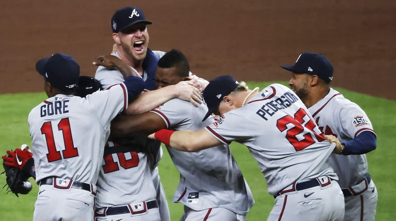 Atlanta pitcher Will Smith (T) celebrates with teammates after defeating...