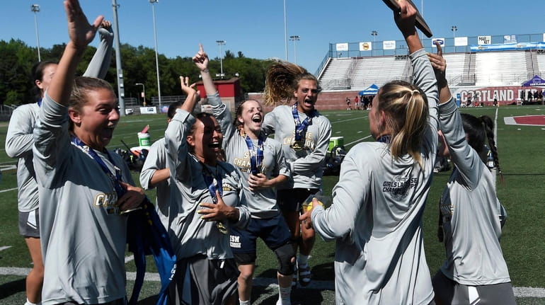 Eastport-South Manor players celebrate with the championship plaque after the...