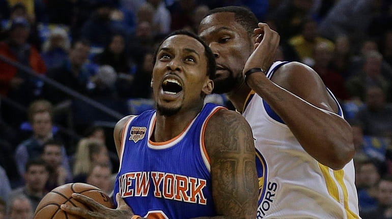 New York Knicks' Brandon Jennings, left, drives the ball around...