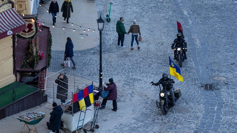 Motorcycle riders with Ukrainian and Ukrainian insurgent army flags pass...