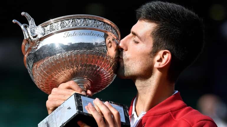 Novak Djokovic holds the trophy after winning the men's final...