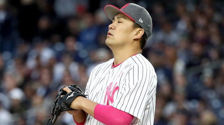 Masahiro Tanaka #19 of the New York Yankees reacts after...