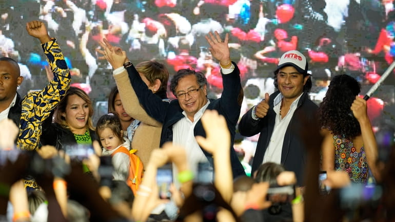 Presidential candidate Gustavo Petro, center, waves to supporters alongside his...