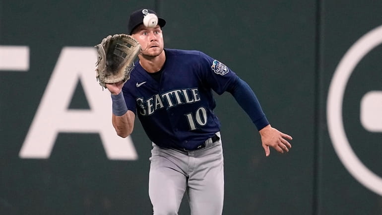 Seattle leftfielder Jarred Kelenic reaches up to catch a fly...