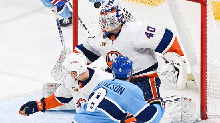 The Canadiens' Mike Matheson scores against Islanders goaltender Semyon Varlamov as Islanders'...