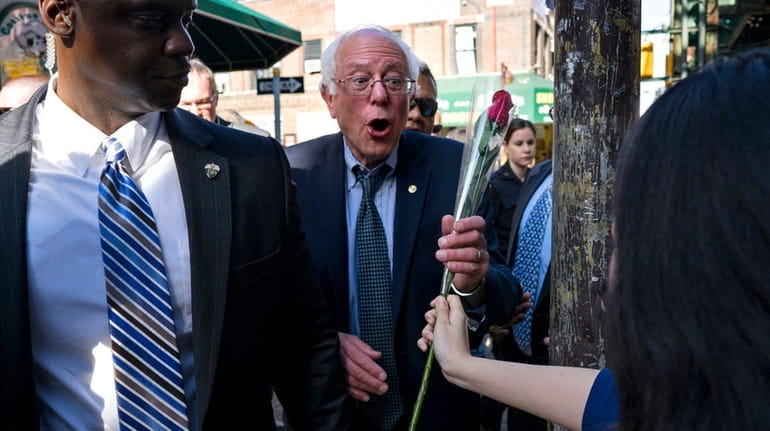 Democratic presidential candidate Sen. Bernie Sanders is handed a rose...