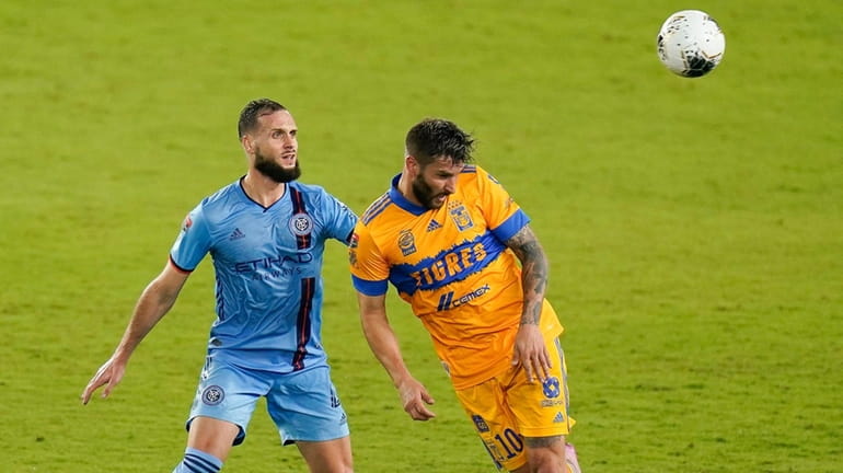 Tigres forward Andre-Pierre Gignac, right, heads the ball away from...