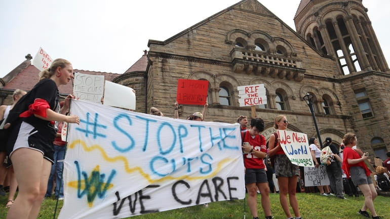 West Virginia University students lead a protest against cuts to...