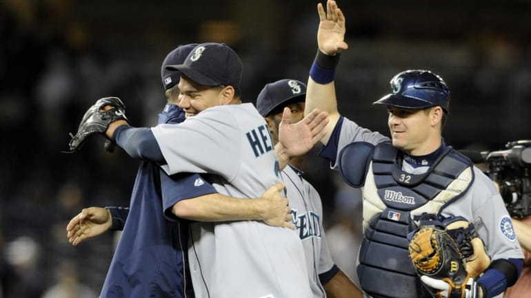 Felix Hernandez is hugged by a teammate after he pitched...