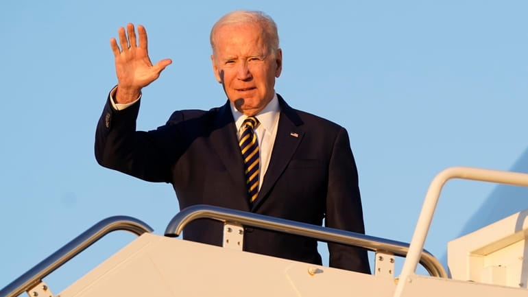 President Joe Biden waves as he boards Air Force One...