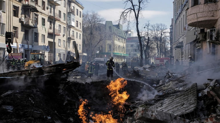 Firefighters extinguish a fire after a Russian rocket attack on an...
