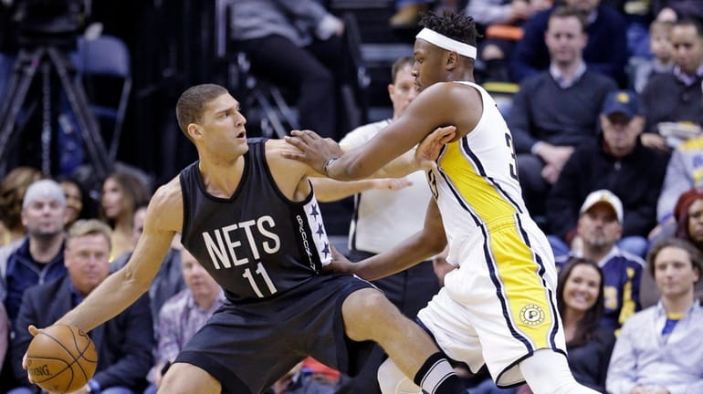Nets center Brook Lopez holds off Pacers center Myles Turner...