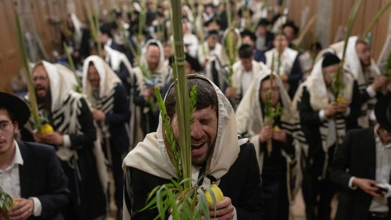 Jewish worshippers pray during the weeklong Jewish holiday of Sukkot,...