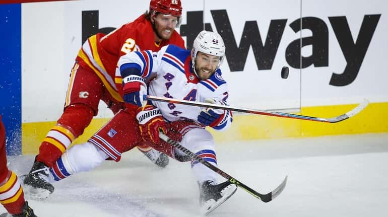 Rangers' Barclay Goodrow, right, competes for the puck agianst Calgary...