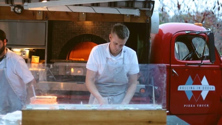 Rolling in Dough owner Matt Michel, 30, makes pizza outside...