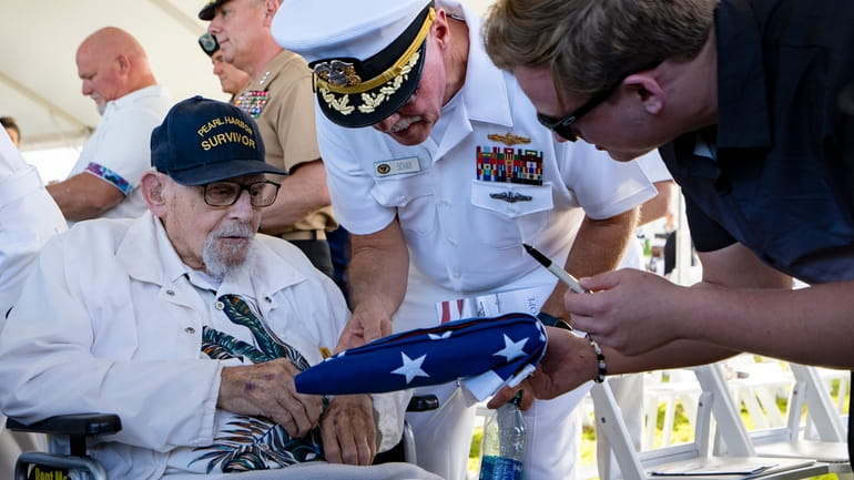An attendee asks Pearl Harbor survivor Ira "Ike" Schab, 103,...