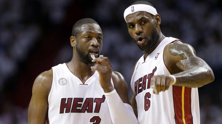 Miami Heat's LeBron James talks with Dwyane Wade during the...