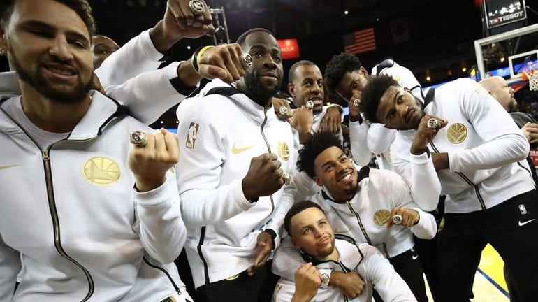 The Golden State Warriors celebrate after receiving their 2017-2018 NBA...