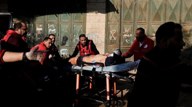 Medics evacuate a wounded Palestinian following an Israeli military raid...