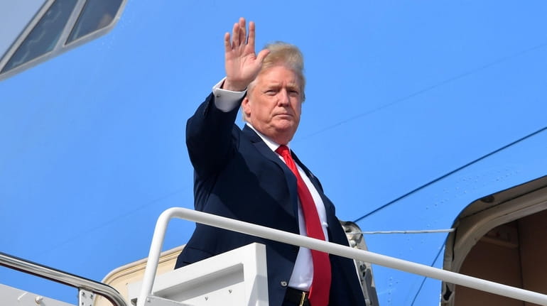 President Donald Trump waves as he boards Air Force One...