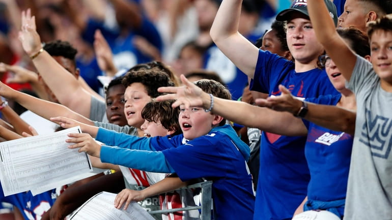 New York Giants fans react for tee shirts during Fan...