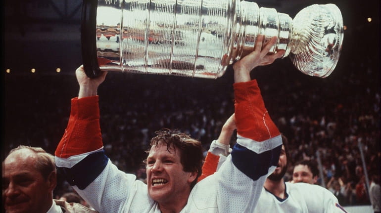 Islanders captain Denis Potvin hoists the Stanley Cup at Nassau...