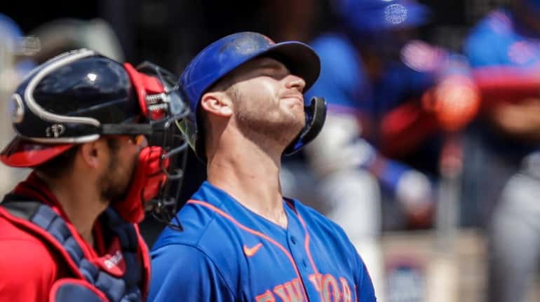 Mets' Pete Alonso, right, reacts after striking out in the...