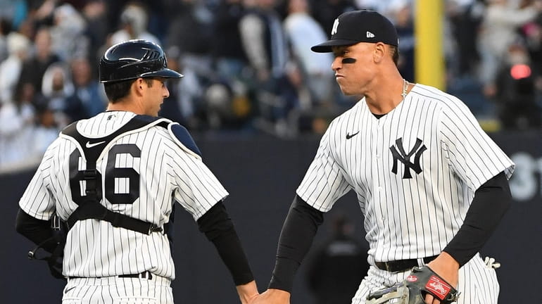 Yankees centerfielder Aaron Judge and catcher Kyle Higashioka celebrate their...