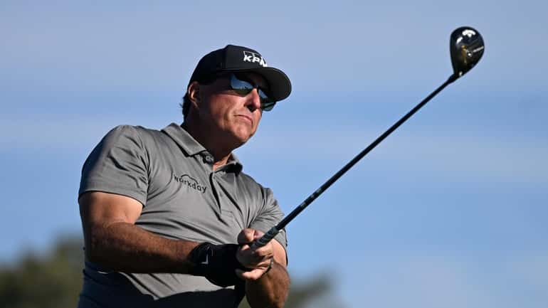 FILE - Phil Mickelson hits his tee shot on the...