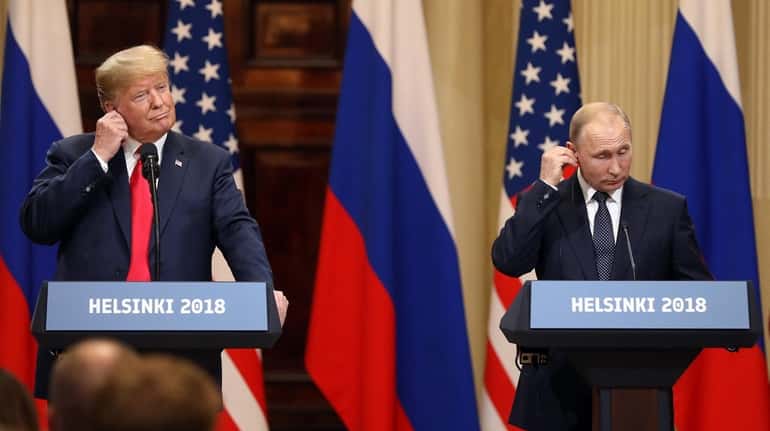 President Donald Trump and Russian President Vladimir Putin adjust their...