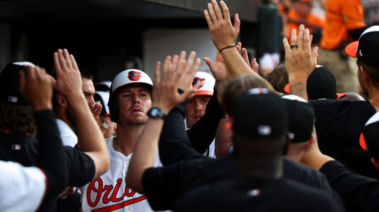 Baltimore Orioles' Ryan O'Hearn and Adley Rutschman celebrates with teammates...