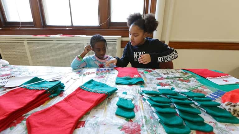 Ke'Miyah Bush, 5, left, and Destiny Rodriguez, 10, decorate Christmas...